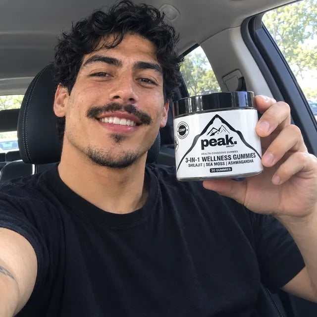Customer holding a jar of Peak 3-in-1 Wellness Gummies in his car